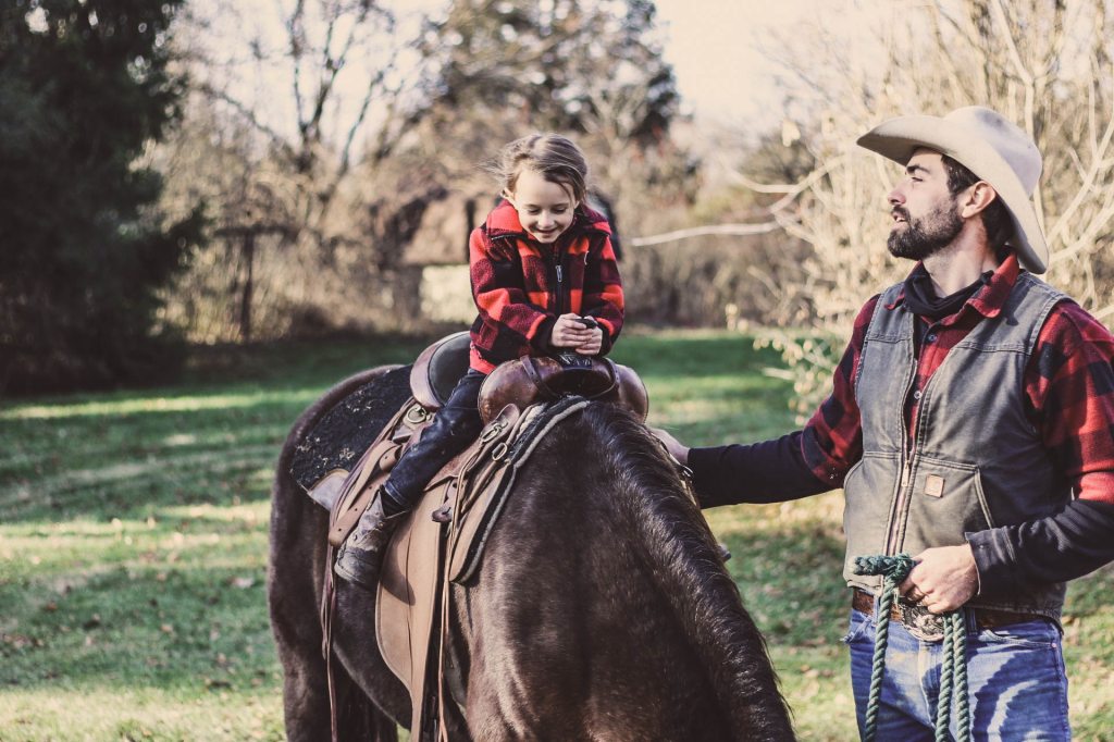 small-boy-horse-back-riding-dad-walking-next-in-plaid